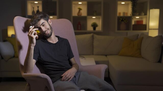 The man who looks at the pills in his hand and is going to commit suicide.