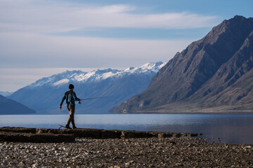 New Zealand mountain and lake landscape with person fishing