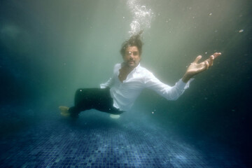 Fototapeta na wymiar Sad man drowning in water in pool