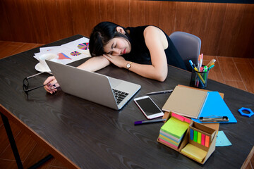 Woman sleeping at desk on desk in office.