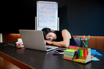 Woman sleeping at desk on desk in office.