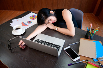 Woman sleeping at desk on desk in office.