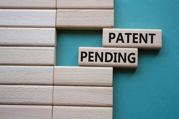 Patent Pending symbol. Concept word Patent Pending on wooden blocks. Beautiful grey green...