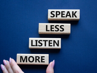 Speak less Listen more symbol. Wooden blocks with words Speak less Listen more. Beautiful deep blue background. Businessman hand. Business and Speak less Listen more concept. Copy space.