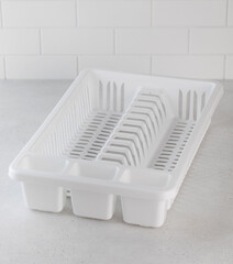 Fototapeta na wymiar Plastic white dish dryer. Accessories for the kitchen, washing dishes.