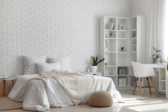 Interior Of Light Children's Bedroom With Cozy Bed, Shelving Unit And Desk Near Window