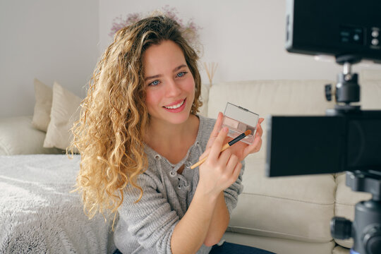 Female blogger recording makeup tutorial at home