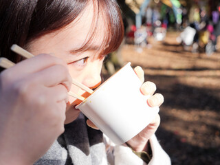 A young asian woman eating noodles or soup - 629243003