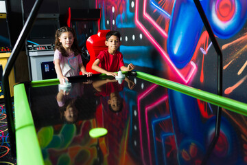 Kids playing air hockey in the fun arcade playroom