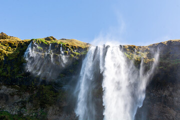 Seljalandsfoss Waterfall - People walking towards the waterfall in Iceland	
