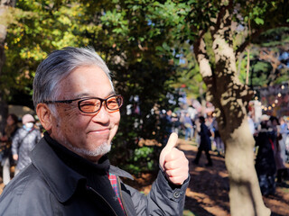 An older Japanese man giving a thumbs up to the camera - 629244622