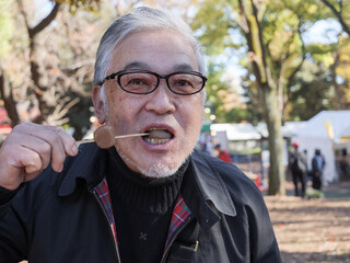 An asian man in glasses eating dango - 629245251