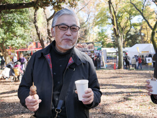 An older Japanese man eating dango and drinking coffee - 629245405