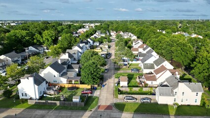 Aerial view of a residential neighborhood surrounded by lush greenery on a sunny day