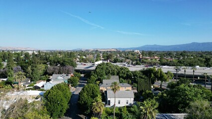 Aerial view of a residential neighborhood surrounded by lush greenery on a sunny day