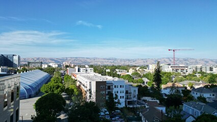 Aerial view of a residential neighborhood surrounded by lush greenery on a sunny day