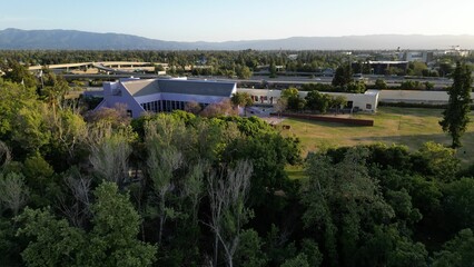 Fototapeta premium Aerial view of a residential neighborhood surrounded by lush greenery on a sunny day