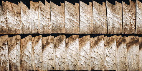 Wooden shingles. Natural roof material of rustic style. Abstract background. Brown and gray color. Old rooftop. Wall facade in village style. Wood pattern. Original surface plank cover. Panoramic