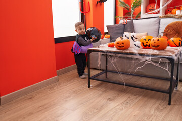 Adorable hispanic boy wearing costume holding balloon at home