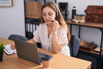 Young blonde woman call center agent smiling confident working at office