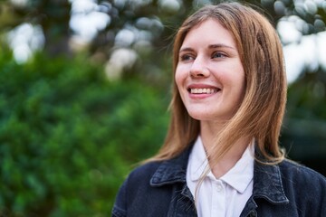 Young blonde woman smiling confident looking to the side at park