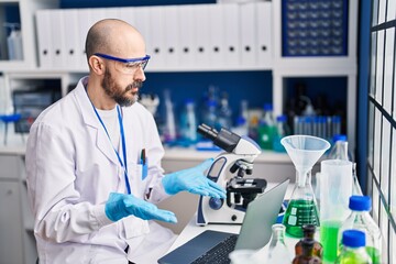 Fototapeta premium Young bald man scientist having video call at laboratory