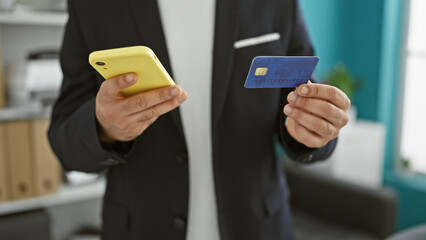 Young arab man business worker shopping with smartphone and credit card at the office