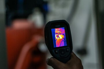 Professional Electrician use thermal infrared camera or thermometer scanning electrical system for preventive maintenance,Industrial thermography,Thermal image of power electric. - obrazy, fototapety, plakaty