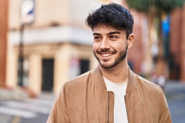 Fototapeta premium Young hispanic man smiling confident looking to the side at street