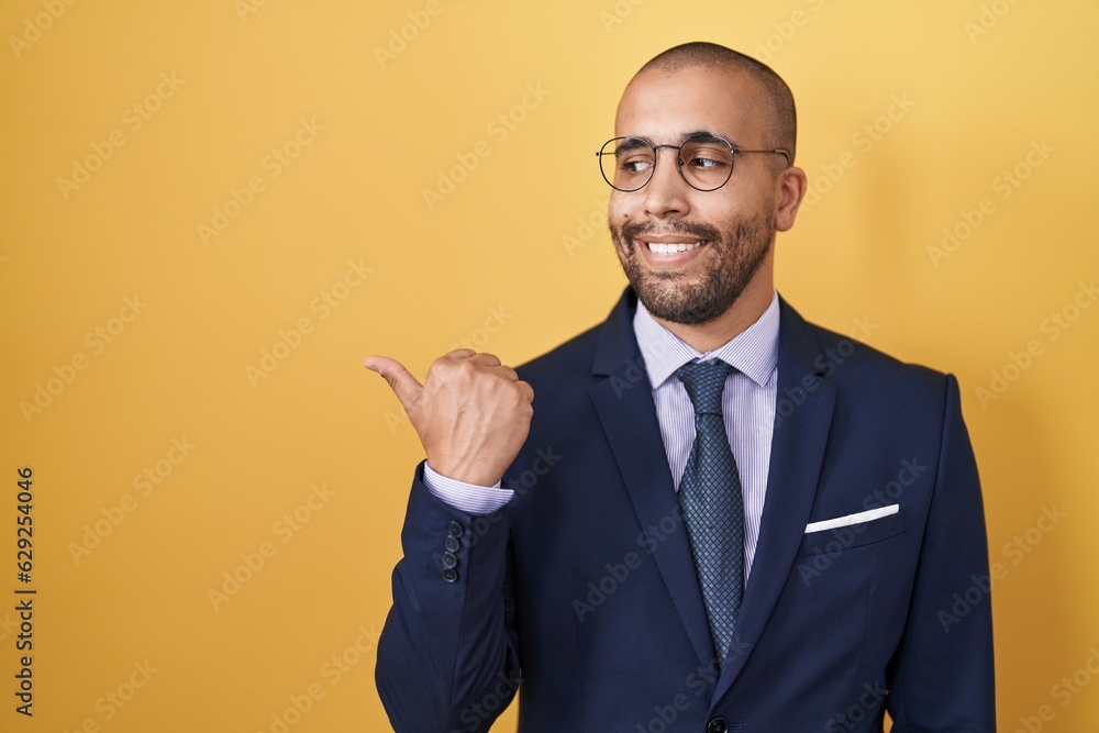 Sticker hispanic man with beard wearing suit and tie smiling with happy face looking and pointing to the sid