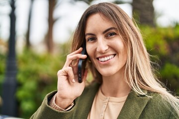 Young woman smiling confident talking on the smartphone at park