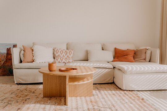 Modern white sofa with a selection of pastel colored pillows in a cozy small living room