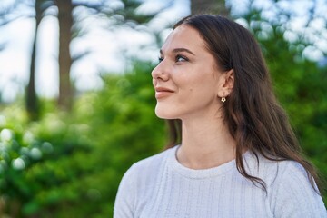 Young woman smiling confident looking to the side at park