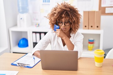 African american woman business worker using laptop and credit card at office