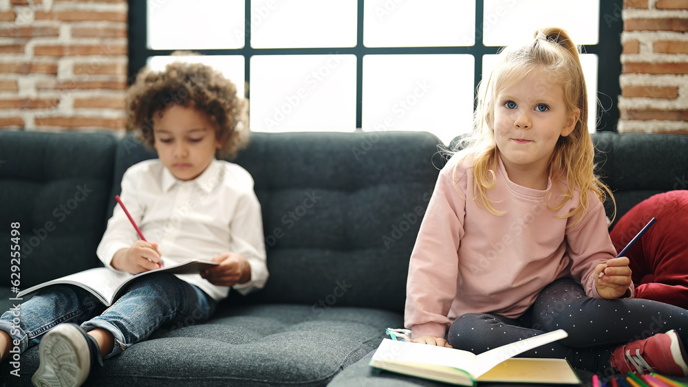 Sticker adorable boy and girl students sitting on sofa drawing on notebook at home