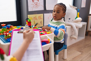 African american boy playing with construction blocks having psychotherapy at kindergarten