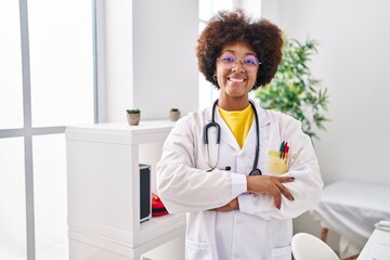 African american woman wearing doctor uniform standing with arms crossed gesture at clinic