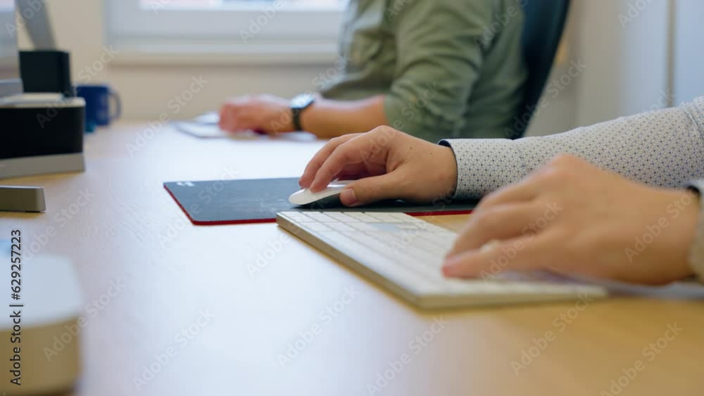 Poster closeup video of a woman working on computer using mouse and keyboard