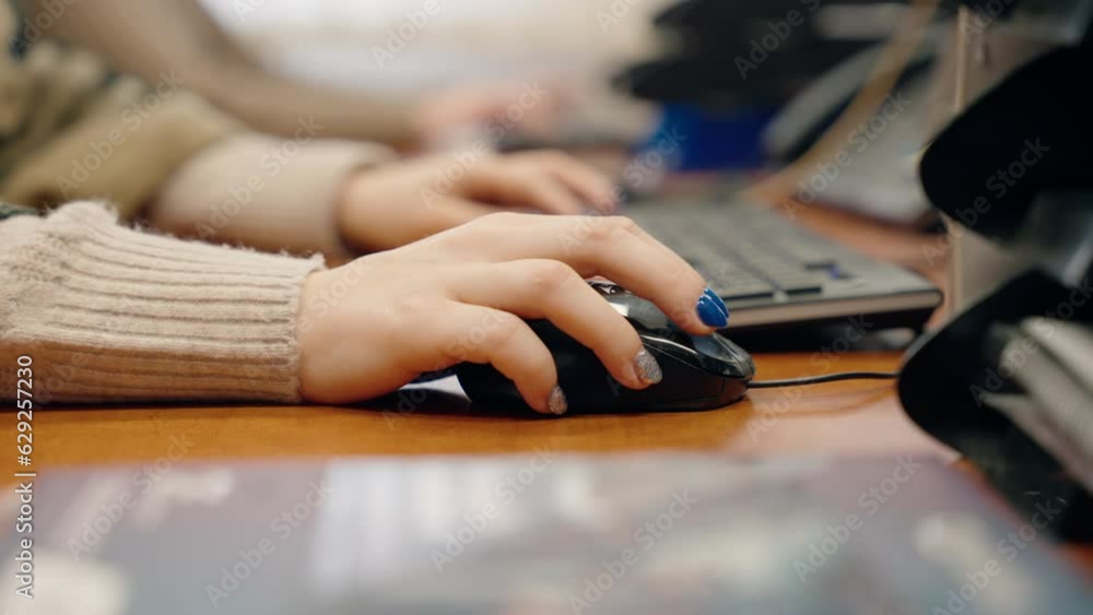 Poster closeup video of a woman working on computer using mouse and keyboard