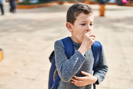 Blond child student coughing at park