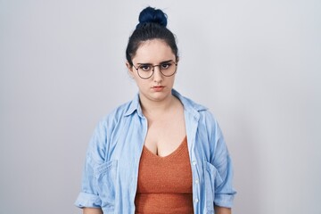 Young modern girl with blue hair standing over white background skeptic and nervous, frowning upset because of problem. negative person.