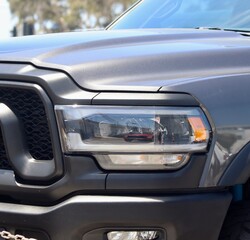 Fototapeta premium Under the brilliant embrace of the sun's warm and golden rays, a sleek black pickup truck stands as the epitome of automotive elegance. Its polished exterior exudes a timeless allure.