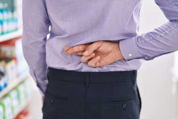 Young hispanic man customer with crossed fingers on back at street