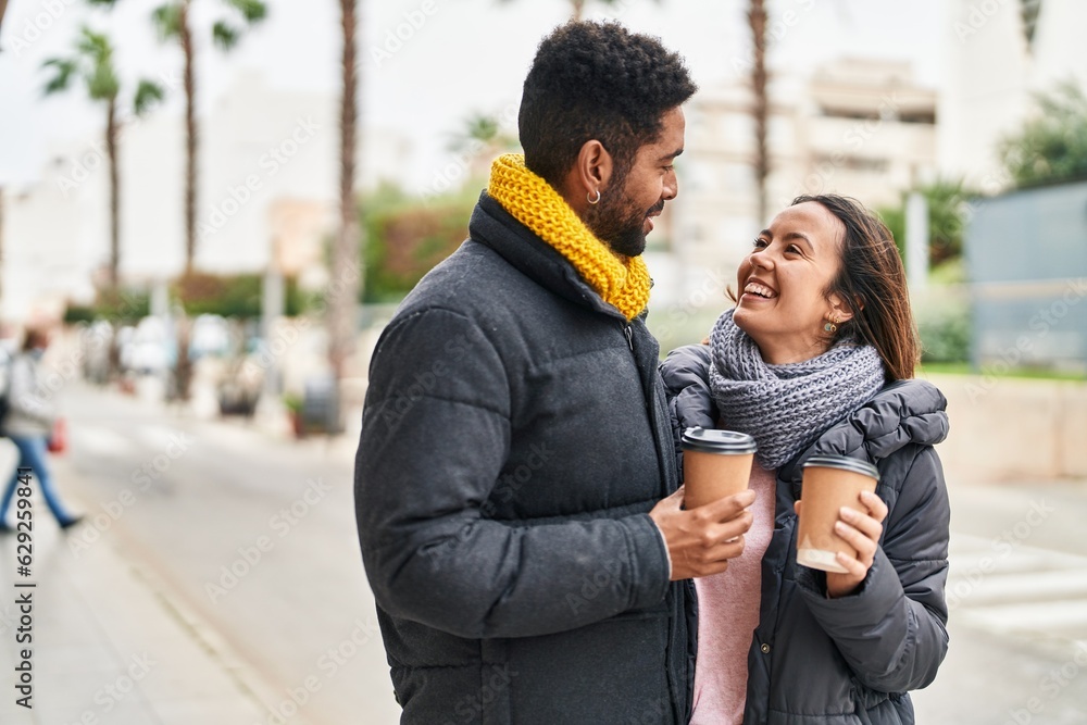 Wall mural Man and woman couple smiling confident drinking coffee at street