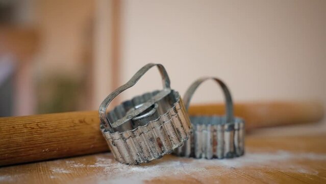 Shortbread cutter and rolling pin on a wooden board.