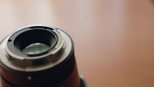 Close-up shot of a mirrorless camera lens on a desk.