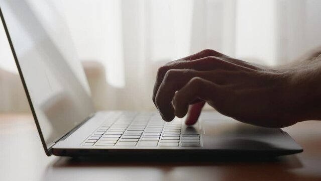 Man start typing on a laptop keyboard.