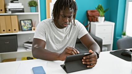 African american man business worker writing on touchpad working at the office