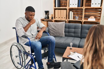African american man doing therapy sitting on wheelchair feeling unwell and coughing as symptom for...