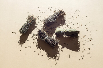 Dry seasoning herbs are tied in bunches on a light background. Top view, flat lay
